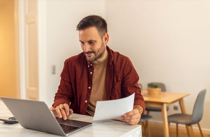 Indépendant traitant ses documents sur son ordinateur portable